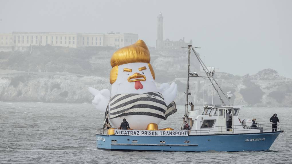 inflatable bird with yellow hair in prison stripes on boat labeled Alcatraz Prison Transport
